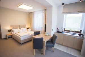 sypialnia z łóżkiem, stołem, łóżkiem i oknem w obiekcie Czarny Kamień Resort & SPA w Szklarskiej Porębie +37 zdjęć