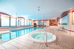 a swimming pool with a hot tub in a building at City Club Hotel in Oldenburg
