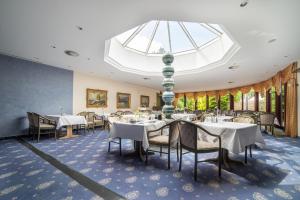 a dining room with tables and chairs and a skylight at City Club Hotel in Oldenburg