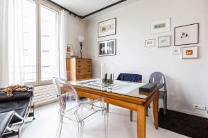 ein Esszimmer mit einem Tisch und Stühlen in der Unterkunft Veeve - White House in Paris