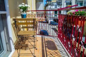 Elle comprend un balcon avec une chaise en bois et des fleurs. dans l'établissement Central Rooms Matera, à Matera