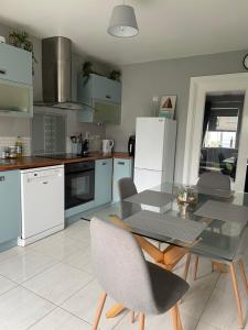 een keuken met een tafel, stoelen en apparatuur bij Ballyhack by the Sea in Arthurstown