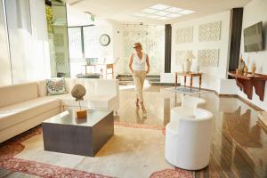 a woman is walking through a living room at Hotel Venus in Gabicce Mare