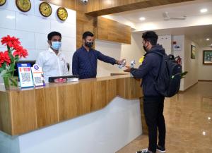 a man is standing at a counter in a pharmacy at Hotel Newyork Inn in Anand