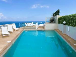 a swimming pool with a view of the ocean at The Diplomat Hotel in Sliema