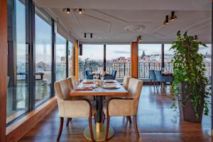 a dining room with a table and chairs and windows at Tiflis Palace in Tbilisi City