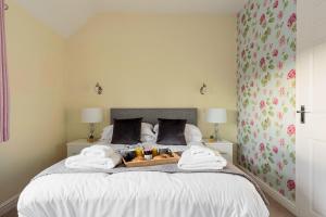 a bedroom with a bed with towels on it at Dell View Cottage in Ashbourne