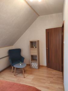 Zimmer mit einem blauen Stuhl und einem Tisch in der Unterkunft Birzītes 5 in Valmiera