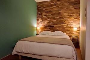 - une chambre avec un grand lit et un mur en briques dans l'établissement ✪ Appt. Rénové - Vue sur mer ✪, à Quiberon