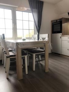 cocina con mesa de madera y sillas en FeWo Vißer‘s Landblick, en Krummhörn