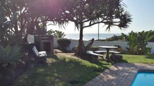 a backyard with a swimming pool and the ocean at Laguna la Crete 99, Uvongo in Margate