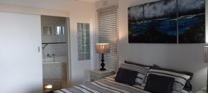 a bedroom with a bed and a lamp and a sink at Laguna la Crete 99, Uvongo in Margate