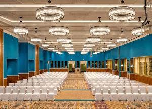 an empty hall with rows of white chairs and tables at Welcomhotel By ITC Hotels, Guntur in Guntūr