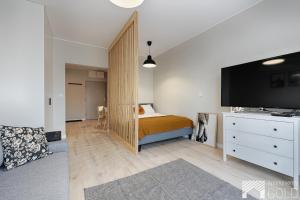sypialnia z łóżkiem i komodą z telewizorem z płaskim ekranem w obiekcie Gdańska Street by LookAp w Łodzi