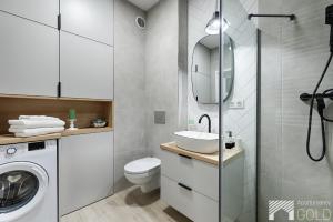 łazienka z umywalką i pralką w obiekcie Gdańska Street by LookAp w Łodzi