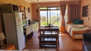 a kitchen with a refrigerator and a table in a room at Thaba Lapeng Mountain Escape in Clarens