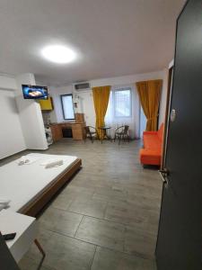 a living room with an orange couch and a tv at Brizza Apartments 5 Mamaia Nord in Mamaia Nord