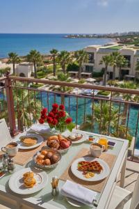 Four Seasons Hotel Tunis في قمرت: طاولة مع طعام الإفطار على شرفة مع المحيط