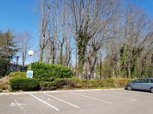 a parking lot with a car parked in it at Kyriad Saint Fargeau Ponthierry - Apollonia in Saint-Fargeau-Ponthierry