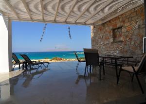 una camera con sedie e tavolo e vista sull'oceano di Kyanis Villa , Karpathos Afiartis ad Afiartis