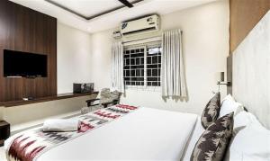 a bedroom with a white bed and a window at StayEasy Tiruvanmiyur (Unit of Prohotel) in Chennai