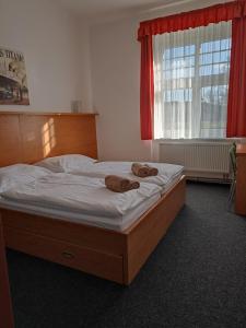 łóżko z dwoma ręcznikami w sypialni w obiekcie Penzion a Restaurace Bělecký Mlýn w mieście Ptení