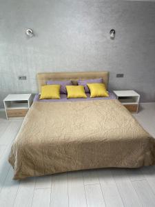 a bedroom with a large bed with yellow pillows at Апартаменты LUX в центре. Ярослава Мудрого 72 (97й квартал) in Kryvyi Rih