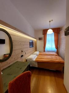 a bedroom with a bed and a window at Hotel Montana- ricarica auto elettriche in Cortina dʼAmpezzo