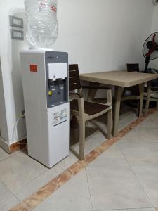 a water heater next to a table and a chair at Down Town apartment Nasr city in Cairo