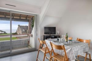 jadalnia ze stołem i krzesłami oraz oknem w obiekcie Appartement accueillant pour 4 personnes, a quelques metres de la plage w mieście Saint-Gildas-de-Rhuys