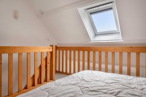 ein Schlafzimmer mit einem Bett und einem Fenster in der Unterkunft À 300m des plages, 2 adultes - 2 enfants in Saint-Gildas-de-Rhuys