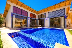 a swimming pool in front of a house at Flower Hotel Patara in Patara