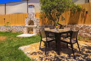 a table and chairs with a fireplace in a yard at Flower Hotel Patara in Patara
