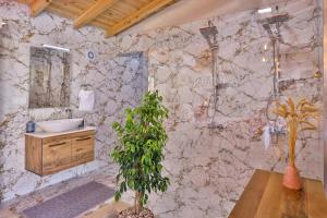 a bathroom with a sink and a marble wall at Flower Hotel Patara in Patara