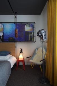 una camera con una macchina fotografica, un letto e una lampada di Zoom Hotel a Bruxelles