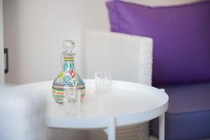 a vase sitting on a table next to two glasses at BLUE Seaside Studio in Sifnos