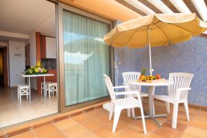 a table and chairs with an umbrella on a patio at 2BR Home next to Esquinzo Beach - Terrace in Pájara