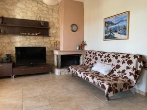 a living room with a couch and a fireplace at Jordan's Stone House in Siviri