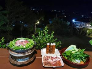 una mesa con dos platos de comida. en นะลาวิว รีสอร์ท ปัว Nala View Resort Pua, en Pua
