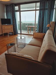 Una sala de estar con un sofá y una ventana grande. en ✪ Appt. Rénové - Vue sur mer ✪, en Quiberon