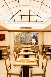 a restaurant with tables and chairs and a large window at The Diplomat Hotel in Sliema