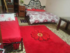 Furnished room just 1 minute to Al ain mall في العين: غرفة نوم بسرير احمر وكرسي احمر