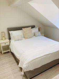 um quarto com uma grande cama branca e uma mesa em The Bluebell Porthmadog em Porthmadog
