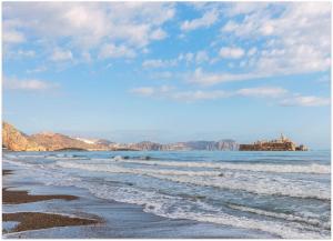 - une plage avec des vagues et des rochers dans l'eau dans l'établissement Radisson Blu Residences Al Hoceima, à Al Hoceïma