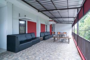 a living room with couches and a table on a balcony at RedDoorz Plus near ITC Cempaka Mas 2 in Jakarta