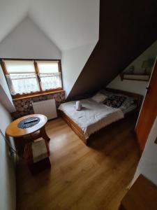 een zolderkamer met 2 bedden en een tafel bij Pokoje Dębowa in Kazimierz Dolny