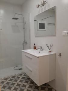 une salle de bain blanche avec un lavabo et un miroir dans l'établissement La Casa de Maricruz, à Cangas de Onís 15 autres photos