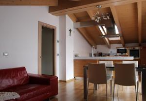 a living room with a couch and a table with chairs at Rafael Wellness Apartment in Livigno