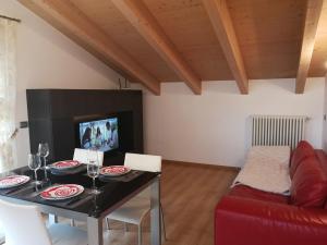 a living room with a table and a red couch at Rafael Wellness Apartment in Livigno