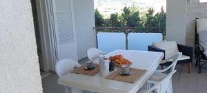 ein weißer Tisch und Stühle mit einer Obstschale darauf in der Unterkunft Casa novellagiovanni, relax mare bellezza in Alcamo